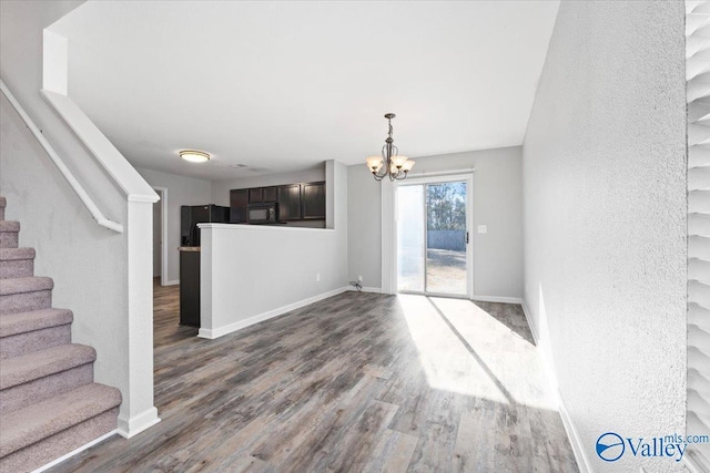 unfurnished dining area featuring dark hardwood / wood-style flooring and a notable chandelier