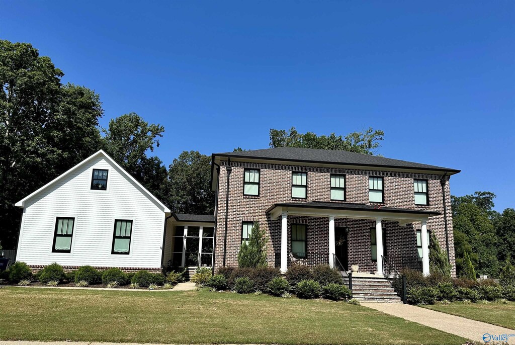 view of front of property with a porch and a front lawn