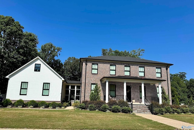 view of front of property with a porch and a front lawn