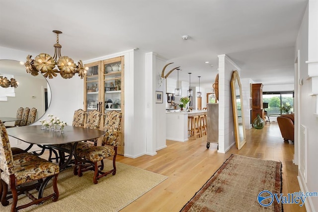 dining area featuring an inviting chandelier and light hardwood / wood-style floors