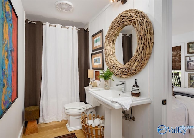 bathroom with hardwood / wood-style flooring and toilet