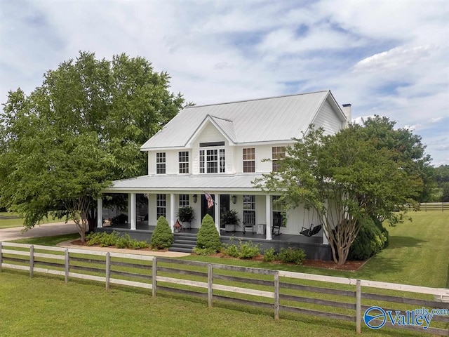 farmhouse-style home featuring a front lawn and covered porch