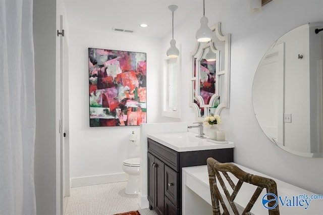 bathroom with tile patterned flooring, vanity, and toilet