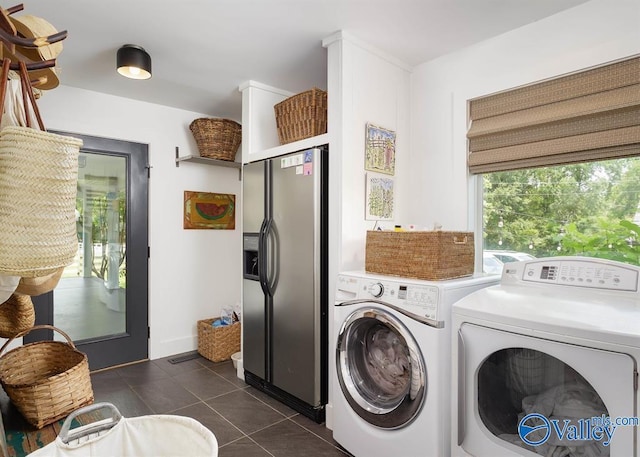 washroom featuring washer and clothes dryer and dark tile patterned flooring