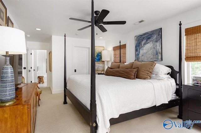 bedroom featuring light colored carpet, ceiling fan, and a closet