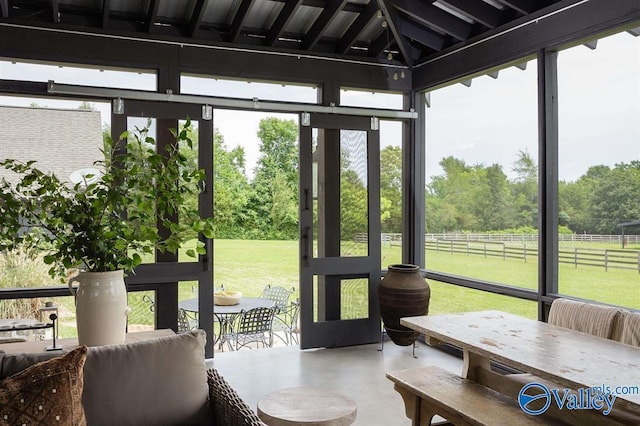 sunroom / solarium featuring plenty of natural light and a rural view