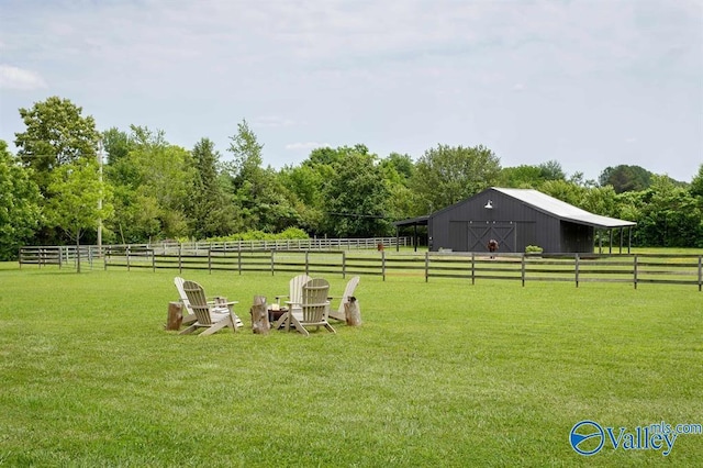 view of yard featuring an outdoor structure and a rural view