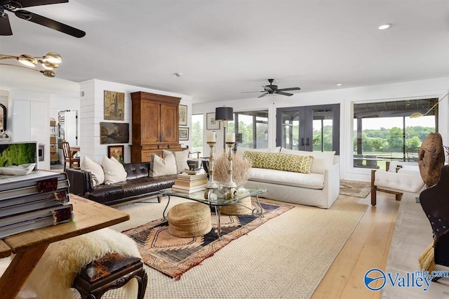 living room featuring ceiling fan, light hardwood / wood-style floors, and french doors