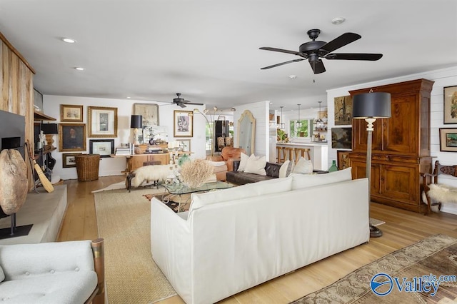 living room featuring ceiling fan and light hardwood / wood-style flooring