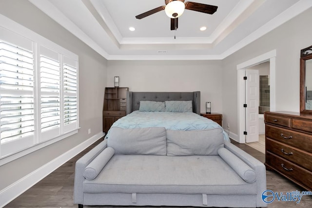 bedroom featuring a tray ceiling, recessed lighting, wood finished floors, and baseboards