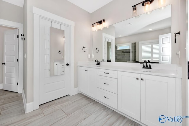 full bath with double vanity, a stall shower, a sink, and baseboards