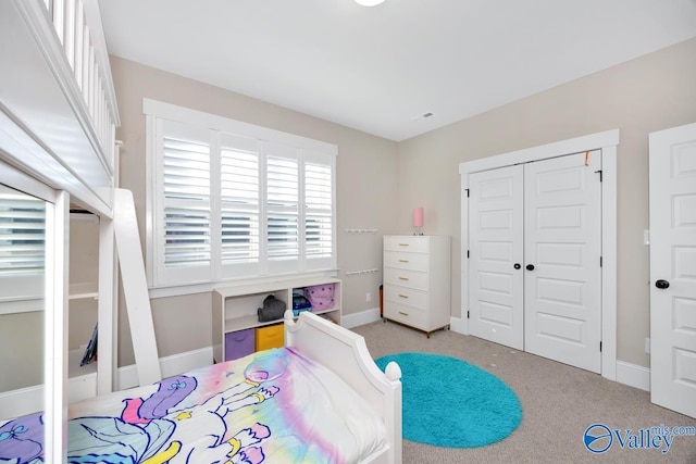 bedroom featuring baseboards, a closet, and light colored carpet