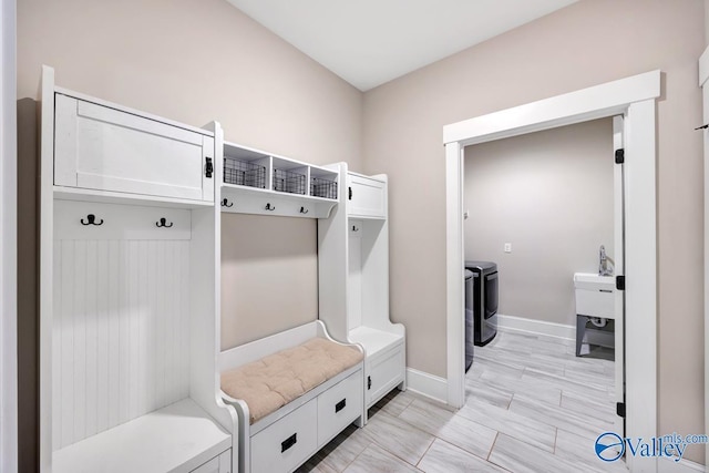 mudroom featuring washer and clothes dryer and baseboards