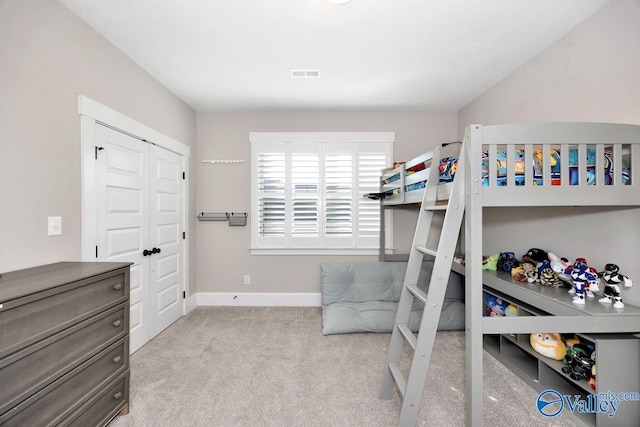 carpeted bedroom with a closet, visible vents, and baseboards