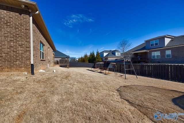 view of yard featuring a fenced backyard and a playground