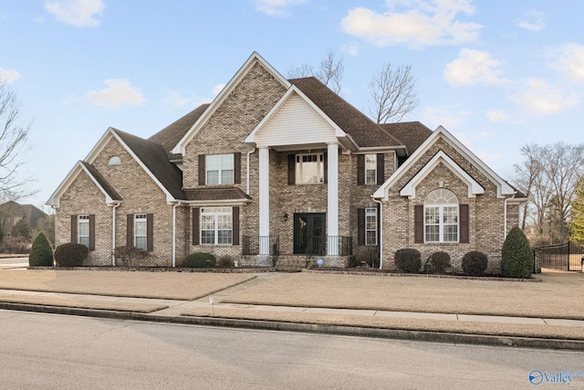 view of front facade featuring fence and brick siding