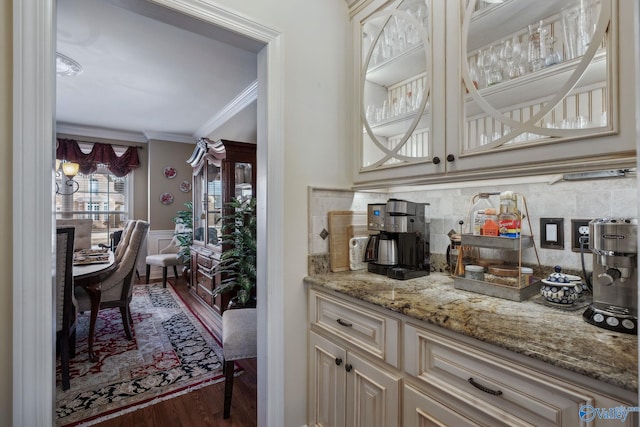 bar with wainscoting, crown molding, backsplash, and wood finished floors