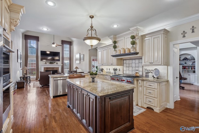 kitchen featuring stainless steel appliances, cream cabinets, and wood finished floors