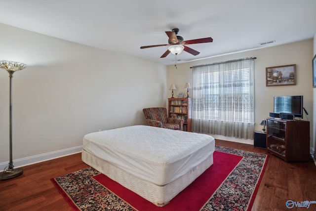 bedroom with visible vents, ceiling fan, baseboards, and wood finished floors