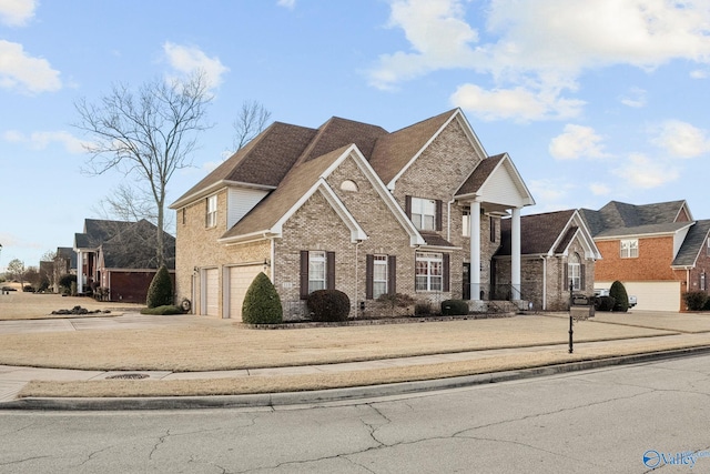 traditional-style house with a garage, driveway, and brick siding