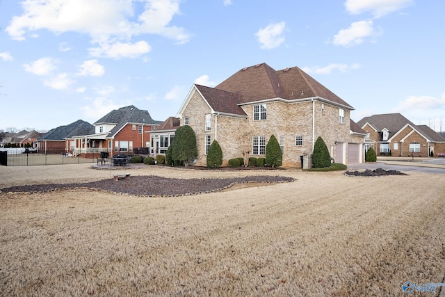 view of front of property with a garage, stone siding, fence, and driveway