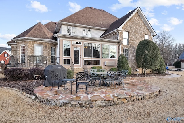 back of house featuring brick siding, a patio area, and a shingled roof