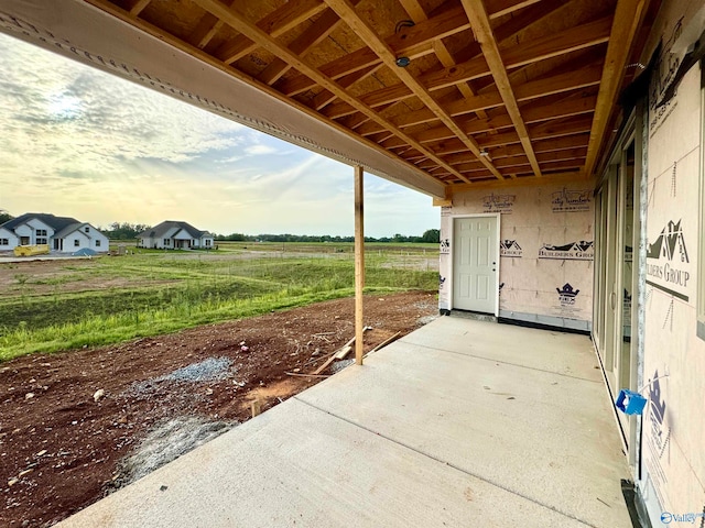 patio terrace at dusk featuring a rural view