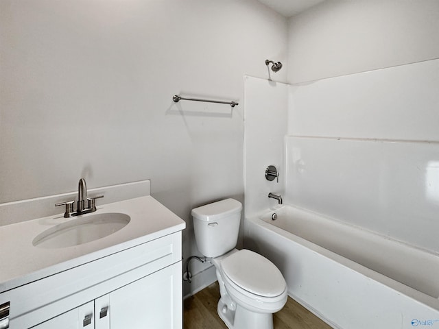 bathroom featuring tub / shower combination, vanity, toilet, and wood finished floors