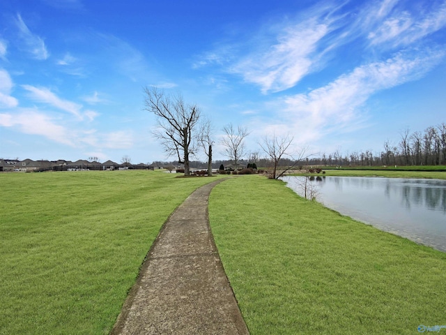 surrounding community featuring a water view and a lawn