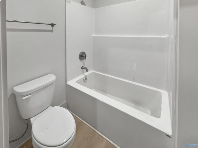 bathroom featuring toilet, wood finished floors, and shower / bathing tub combination