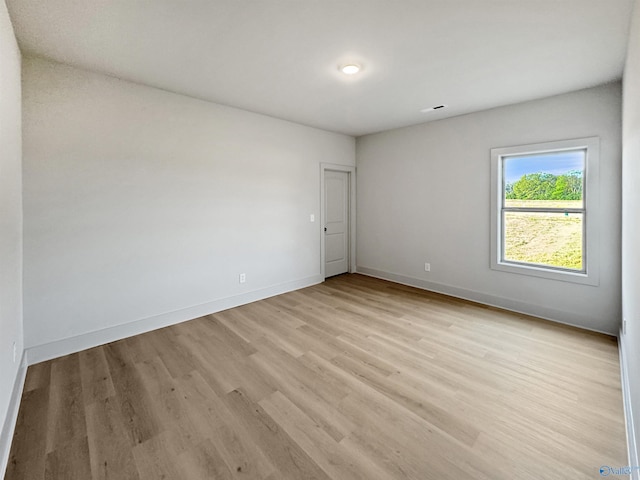 spare room with light wood-style flooring and baseboards