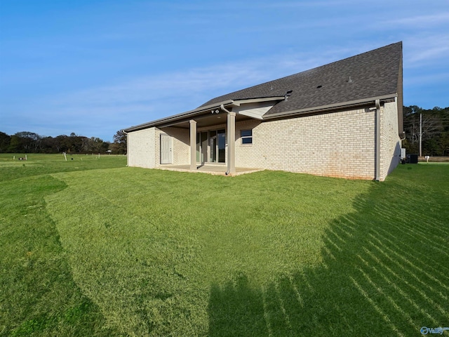 rear view of house with a lawn and a patio area