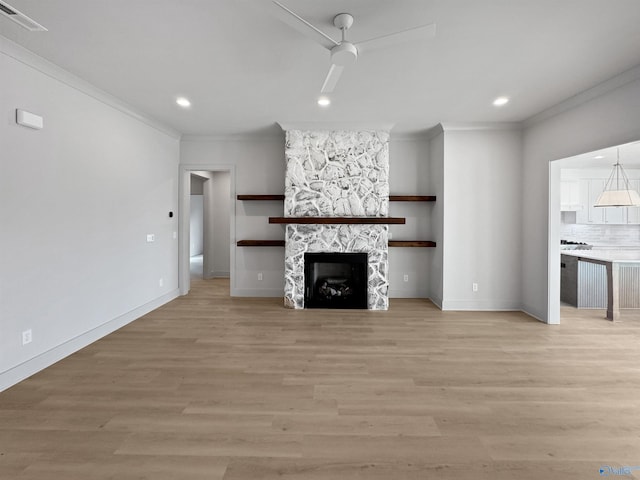 unfurnished living room with ceiling fan, light wood-type flooring, a fireplace, and visible vents