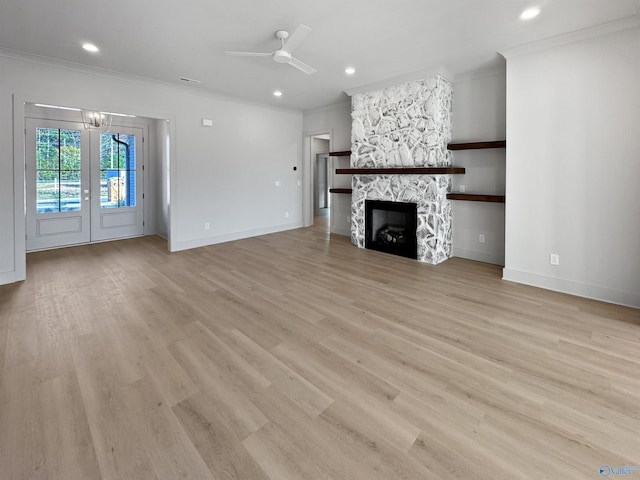 unfurnished living room with light wood-type flooring, a fireplace, and crown molding