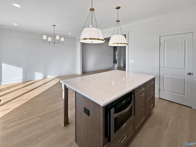 kitchen featuring wall oven, dark brown cabinetry, light wood-style flooring, recessed lighting, and pendant lighting