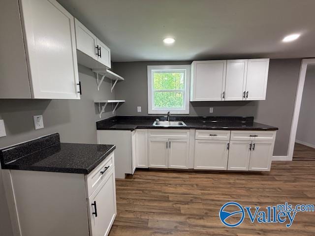 kitchen with white cabinetry, open shelves, dark wood-type flooring, and a sink