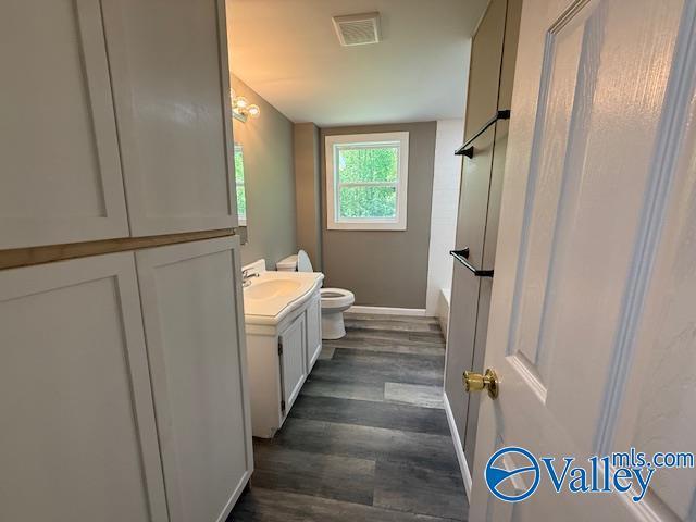full bath featuring visible vents, toilet, shower / bath combination, wood finished floors, and vanity