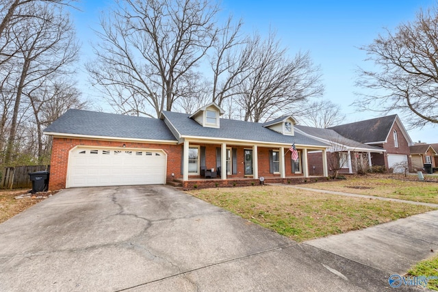 view of front of property featuring a front lawn, a garage, and a porch