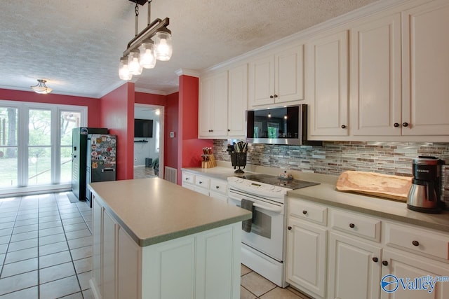 kitchen featuring a textured ceiling, stainless steel microwave, backsplash, white range with electric cooktop, and light tile patterned floors
