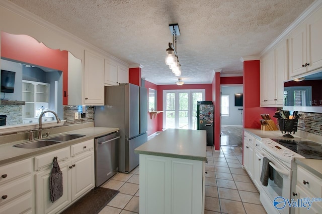 kitchen with a sink, a kitchen island, appliances with stainless steel finishes, and tasteful backsplash