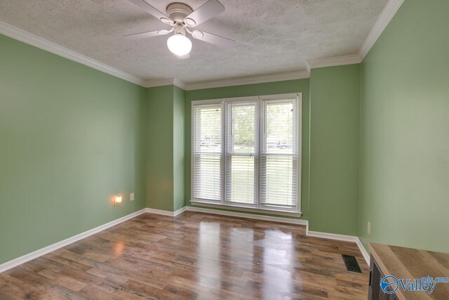 empty room with wood finished floors, a textured ceiling, ceiling fan, baseboards, and visible vents
