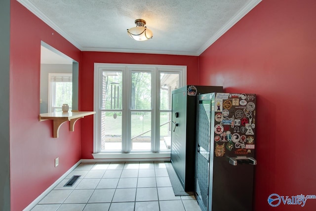 doorway to outside featuring plenty of natural light, baseboards, visible vents, and a textured ceiling