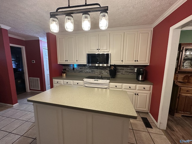 kitchen featuring stainless steel microwave, a textured ceiling, white electric range oven, and backsplash