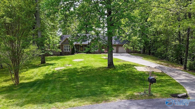 view of front of house featuring concrete driveway, an attached garage, and a front yard