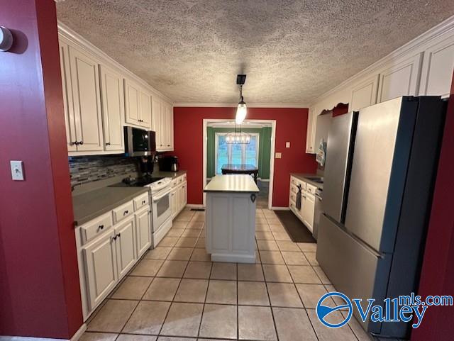 kitchen with light tile patterned floors, a center island, white cabinetry, and stainless steel appliances