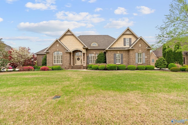 view of front of property with roof with shingles, brick siding, and a front lawn