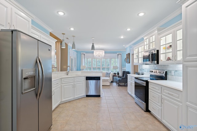 kitchen featuring crown molding, a peninsula, white cabinetry, a sink, and stainless steel appliances