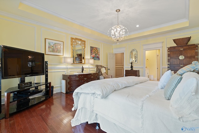 bedroom featuring a chandelier, a decorative wall, dark wood-style flooring, and a tray ceiling