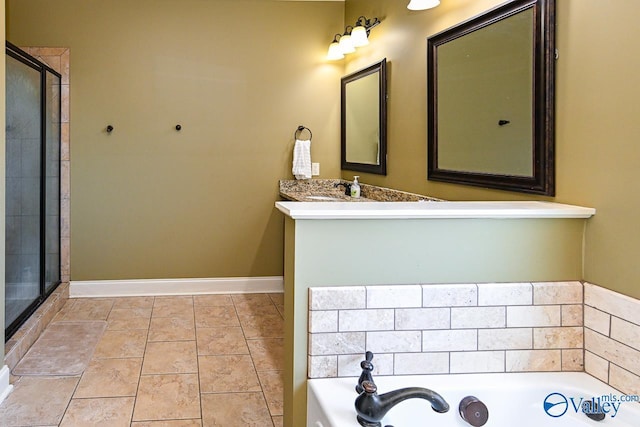 full bathroom featuring vanity, baseboards, tile patterned flooring, a shower stall, and a garden tub