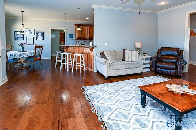 living room featuring dark wood finished floors, crown molding, and ceiling fan